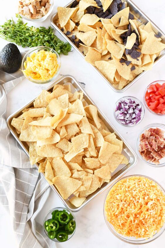 hearty breakfast nachos, Nachos on a baking sheet with ingredient toppings around it