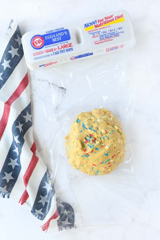 red white and blue sprinkle pudding cookies, Patriotic cookie dough in plastic wrap on a white table