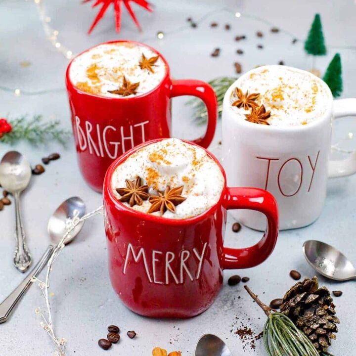 grapefruit cold brew coffee, red and white mugs with the writing merry joy and bright on them full of coffee and steamed milk