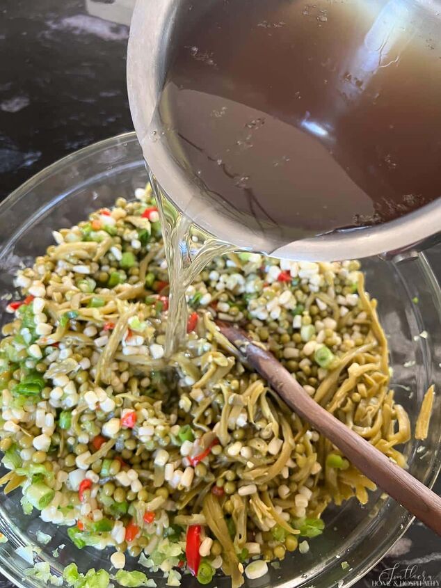 easy marinated shoepeg corn vegetable salad recipe, Pouring the oil and vinegar dressing over English pea green bean and corn salad