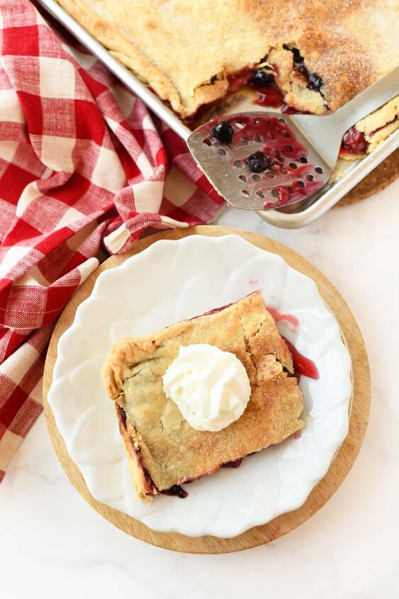 cherry blueberry slab pie a crowd pleasing dessert, Pie of berry pie with whipped cream on a white plate
