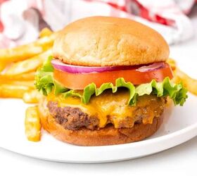 easy to make cast iron skillet burgers, A hamburger on a bun on a white plate with lettuce and tomato