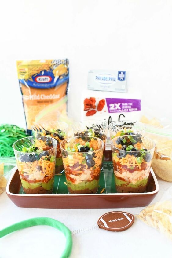 7 layer game day individual dip cups, Mexican 7 layer dip cups with kraft cheese and vanity fair napkins on the table There is also a football headband there