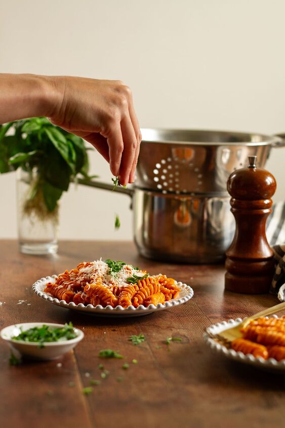 fusilli alla vodka spicy tomato vodka pasta cream sauce, Pasta alla Vodka being served topped with grated Parmesan and showing the parsley being added