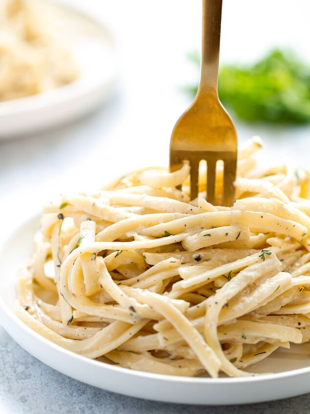 fusilli alla vodka spicy tomato vodka pasta cream sauce, A bowl of pasta with creamy white wine sauce on a pale blue background