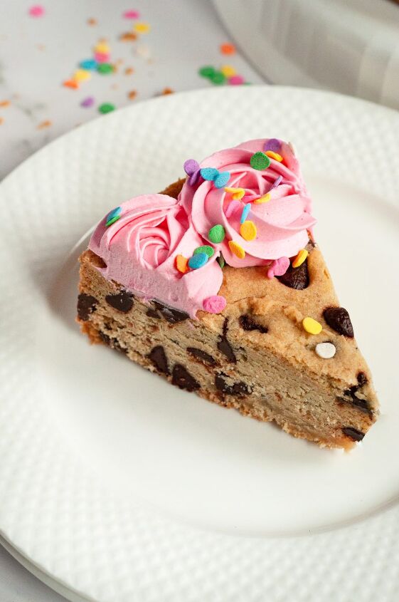 gluten free chocolate chip cookie cake vegan, A giant chocolate chip cookie cake topped with pink frosting rosette swirls and pastel colored sprinkles