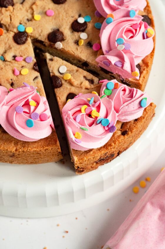 gluten free chocolate chip cookie cake vegan, A giant chocolate chip cookie cake topped with pink frosting rosette swirls and pastel colored sprinkles