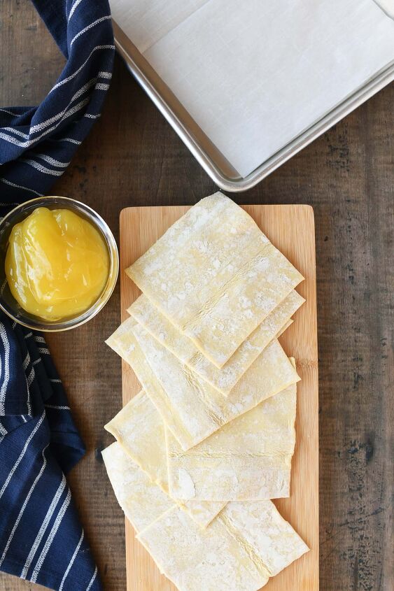 iced lemon turnovers, Puff pastry sheets for turnovers uff pastry dough cut into small squares on a wooden cutting board