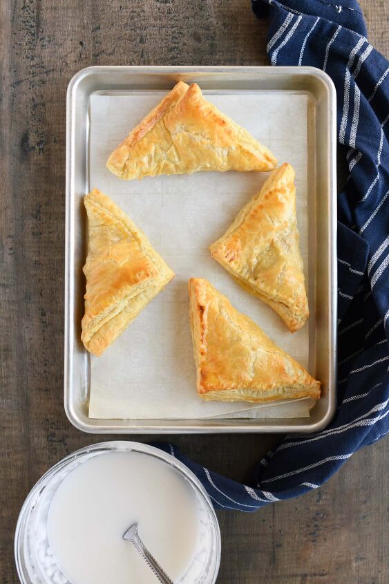 iced lemon turnovers, Baked Lemon Turnovers on a parchment lined baking sheet