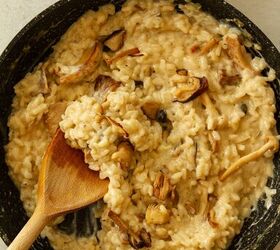 risotto ai funghi mushroom garlic and parmesan risotto, Stirring in in the Parmesan cream balsamic vinegar and mushrooms with a wooden spoon in a dark coloured frying pan