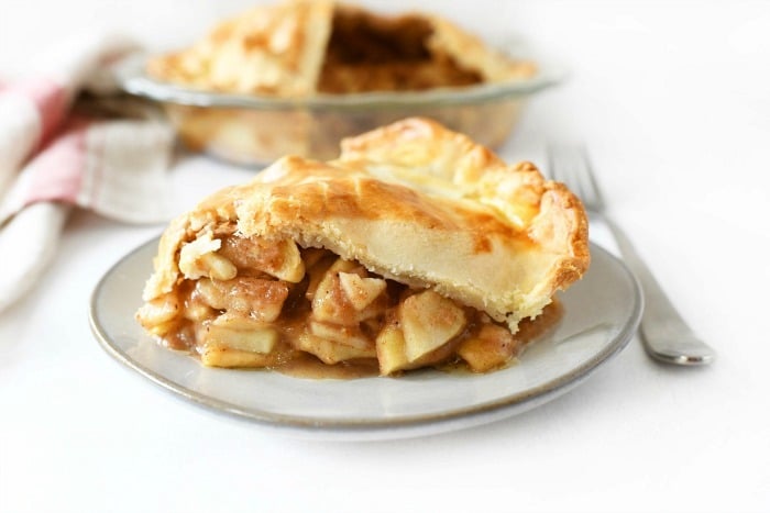 easy apple pie using store bought crust, sliced apple pie on a grey dish with a fork
