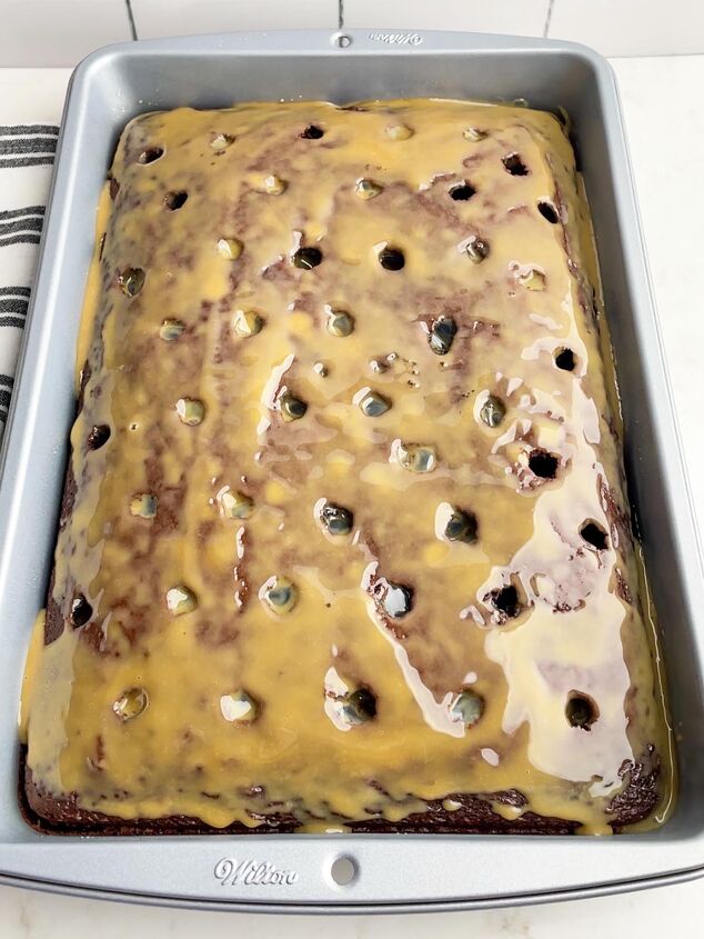 chocolate cake with holes on top drizzled with caramel sauce