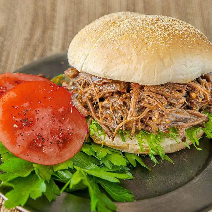red robin inspired mushroom swiss burger recipe, Sandwich with shredded beef on bun and tomatoes on the side