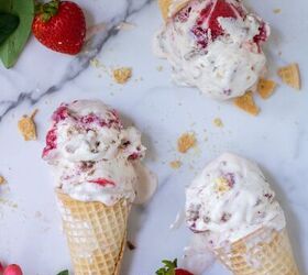 3 ice cream cones with strawberry crumble ice cream There s crumbs around the cones and whole fresh strawberries