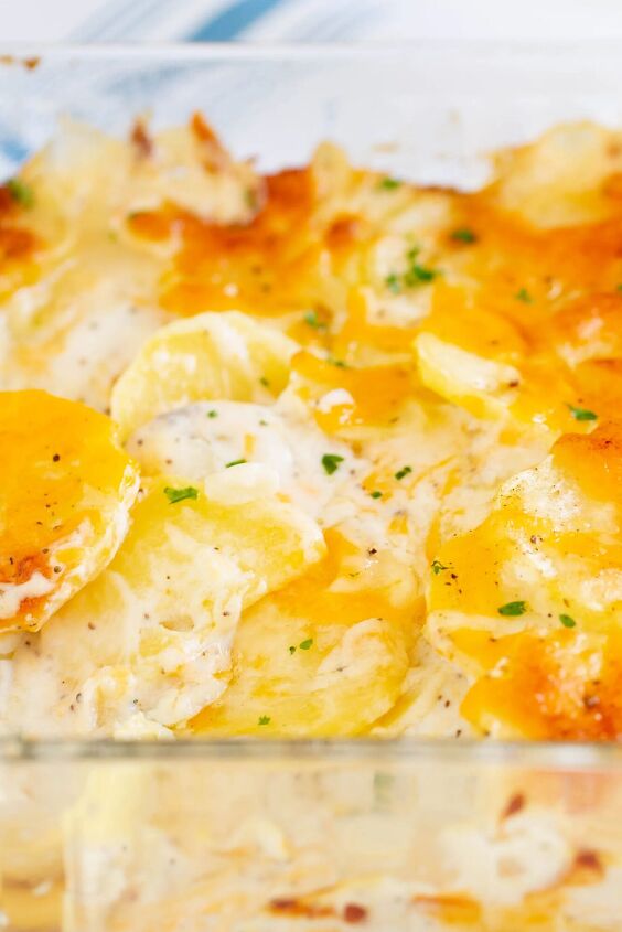 the best scalloped potatoes with mushroom soup, up close view of dish of scalloped potatoes loaded with cheese and creamy sauce