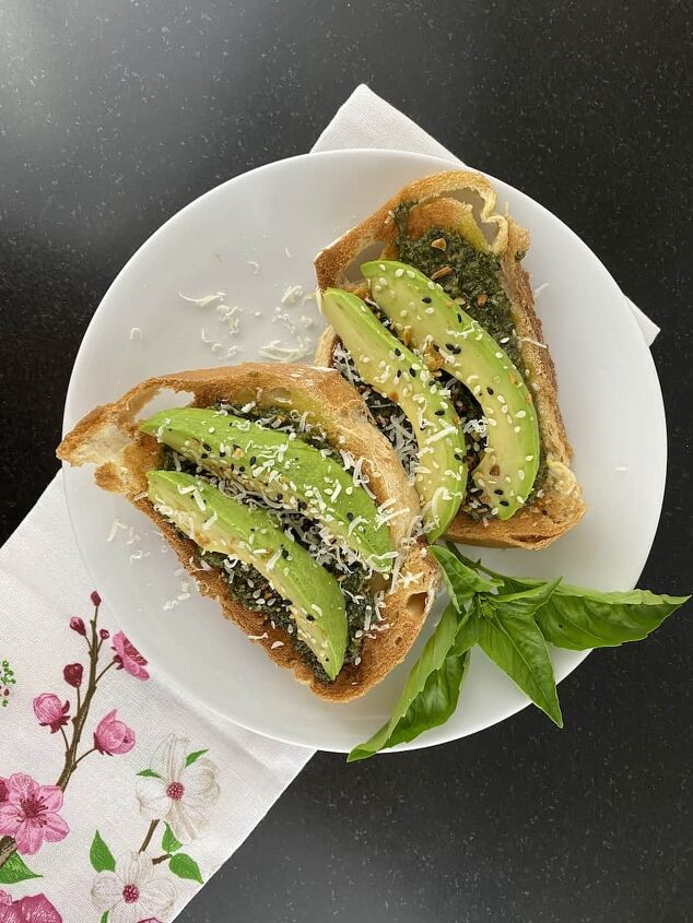5 easy ways to use fresh basil from your garden, photo of toast with pesto sauce sliced avocado and everything but a bagel seasoning on top