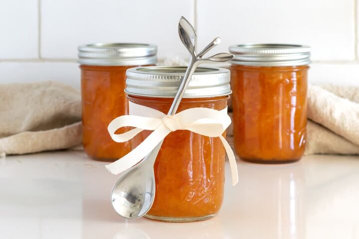 Jar of peach preserves with a ribbon and a small spoon tied in the ribbon