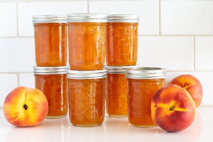 Jars of peach preserves with fresh peaches