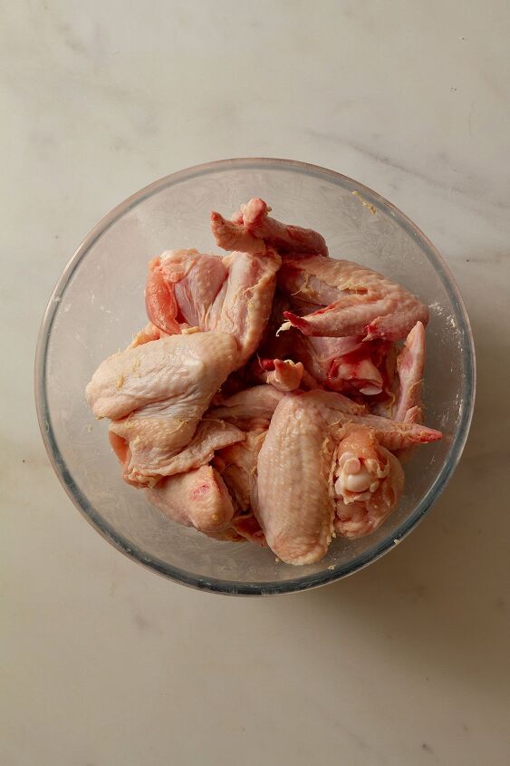 garlic butter chicken wings oven baked and super crispy, Chicken wings in a glass bowl ready for the addition of the baking powder and salt