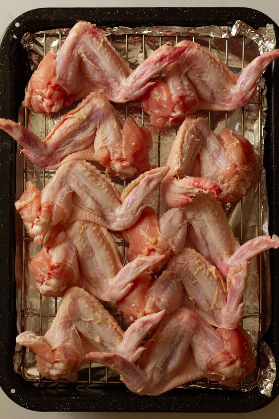 garlic butter chicken wings oven baked and super crispy, Wings prepared prior to cooking on a wire rack on a tray lined with kitchen foil