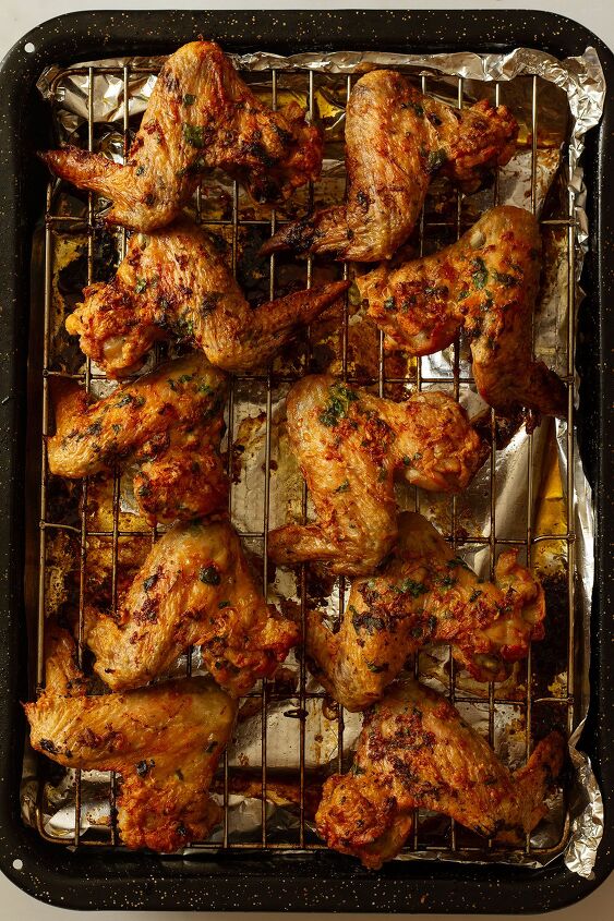 garlic butter chicken wings oven baked and super crispy, Cooked chicken wings after being returned to the oven for 5 8 minutes until they are super crispy On a wire rack on a tray lined with kitchen foil