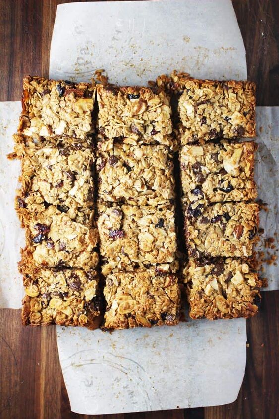 chewy granola bars, Freshly baked chewy granola bars cut into squares on a sheet of parchment