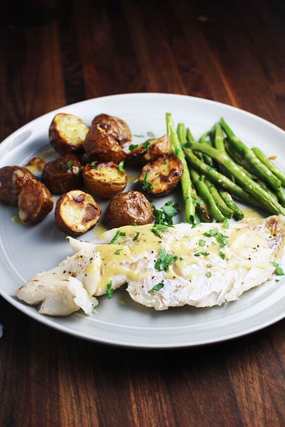 sheet pan dinner with fish and brown butter sauce, fish green beans and potatoes on a plate for a sheet pan dinner