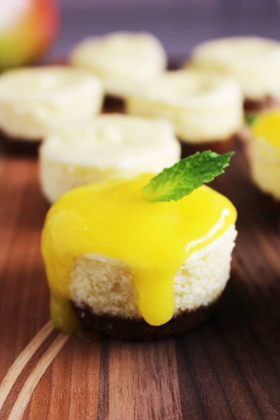 Mini cheesecake topped with mango coulis and a mint leaf