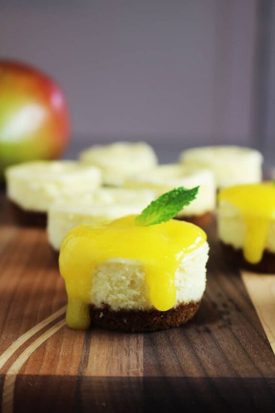 Mini cheesecakes with mango and biscoff crust on a wooden board