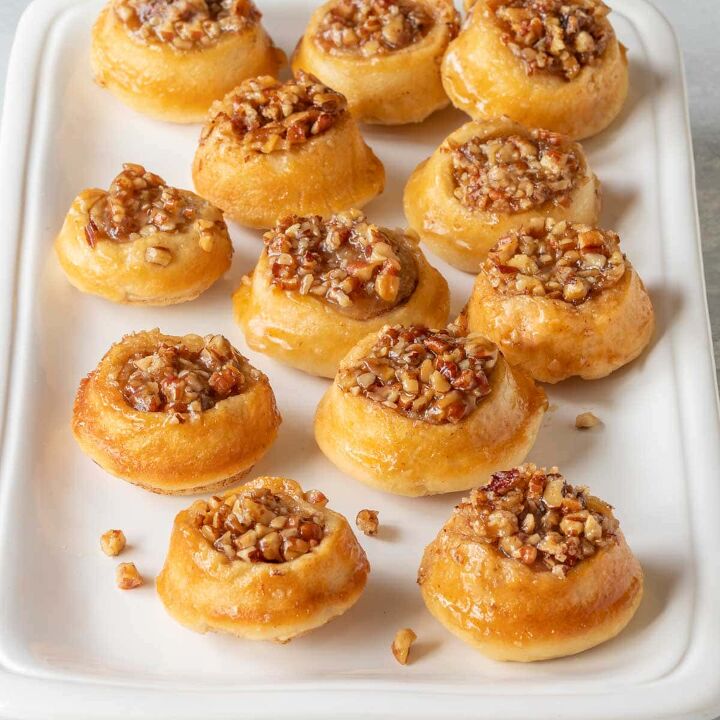 irresistibly delicious and easy to make a guide to creating mini peca, white platter holding around 1 dozen mini pecan rolls