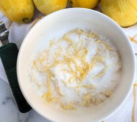 how to make lemon sugar to flavor desserts and drinks, A white bowl of sugar and citrus zest threads on a white and gold towel