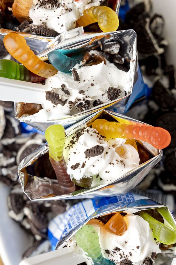 make everyone happy with this walking cup of dirt dessert, up close and over the top photo of walking dirt cup desserts with gummy works and crushed oreos