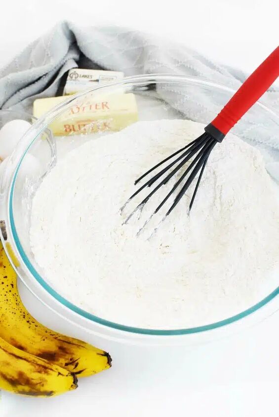 easy banana cake with maple cream cheese frosting, mixing bowl with batter and ripe bananas on a white table