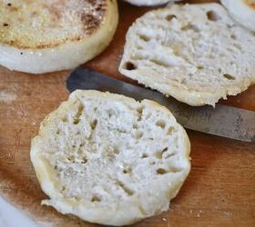 easy sourdough english muffins, sourdough English muffin cut open on wooden cutting board with knife