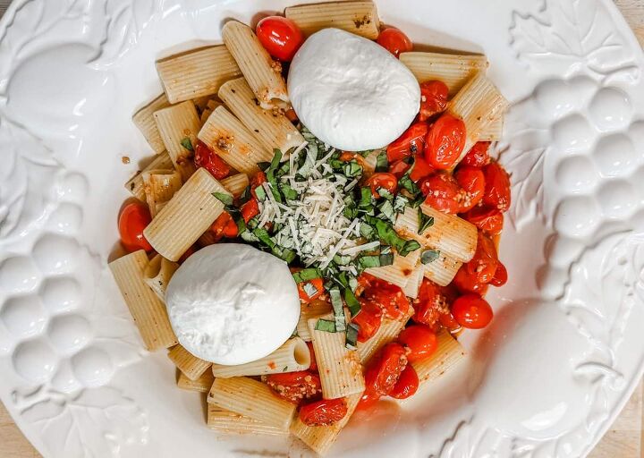 pasta with burst cherry tomatoes topped with burrata cheese, a bowl of pasta with burst cherry tomatoes topped with burrata cheese