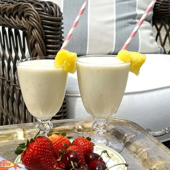 how to make delicious bedtime lavender chamomile vanilla milk, How to Make Easy and Delicious Pineapple Smoothies whole strawberries whole cherries pineapple chunk paper straws pink and white silver serving tray with handles grey and beige striped outdoor pillow