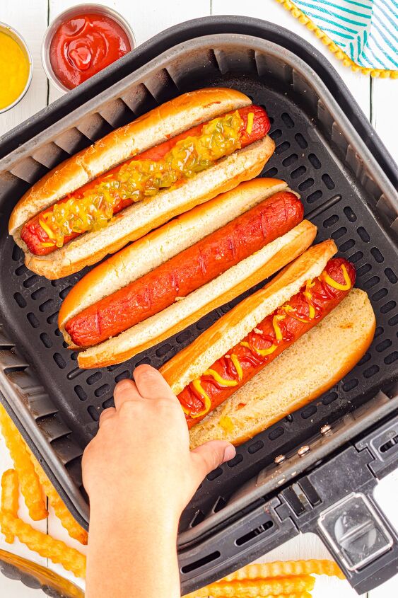 air fryer hot dogs, Child s hand grabbing a hot dog from the air fryer