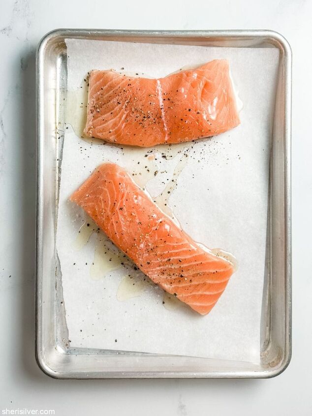 easiest ever salmon with chickpeas and arugula, salmon fillets on a parchment lined baking sheet