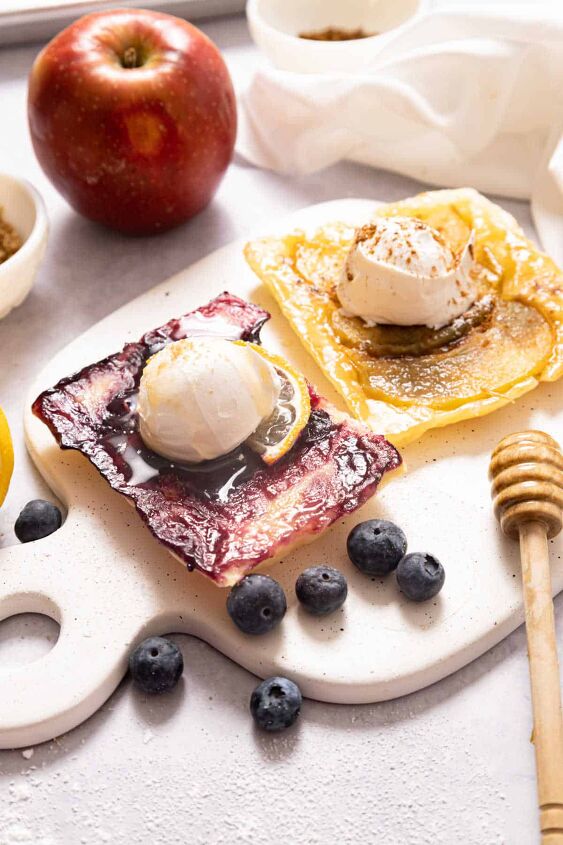 puff pastry fruit tarts, A blueberry and an apple tart on a white board