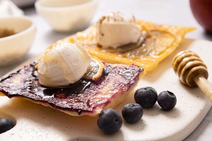 puff pastry fruit tarts, A blueberry tart and an apple tart with scoops of ice cream on top