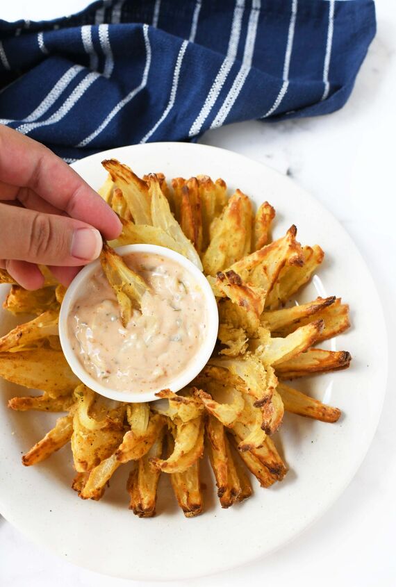 make an air fryer onion blossom at home, Onion petals and sauce in a hand