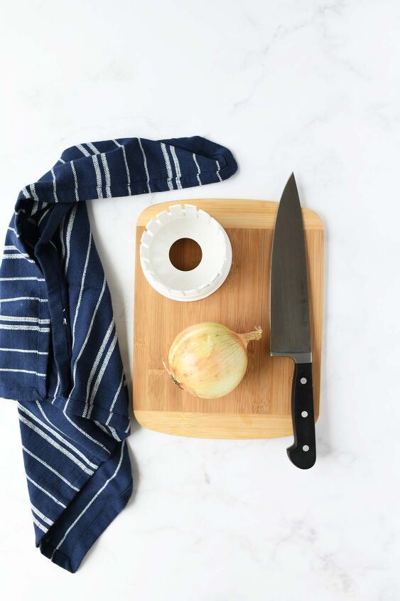 make an air fryer onion blossom at home, An onion and onion cutter on a wooden cutting board