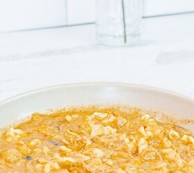 how to make the most amazing chicken paprikash soup in 30 minutes, gray bowl filled with chicken paprikash and dumplings on a white table with a vase in the background