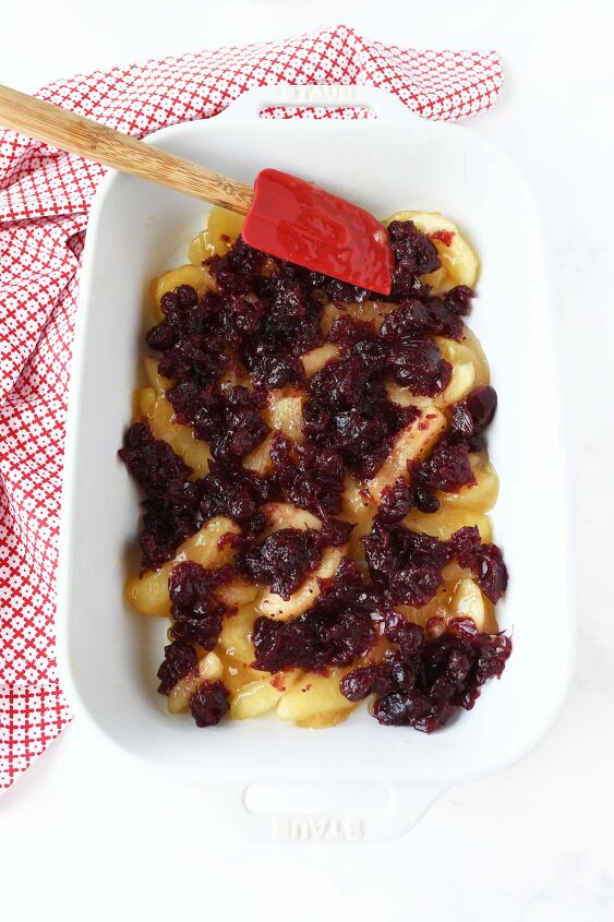 fall cranberry apple dump cake, Cranberries and apples smoothed out in a white pan