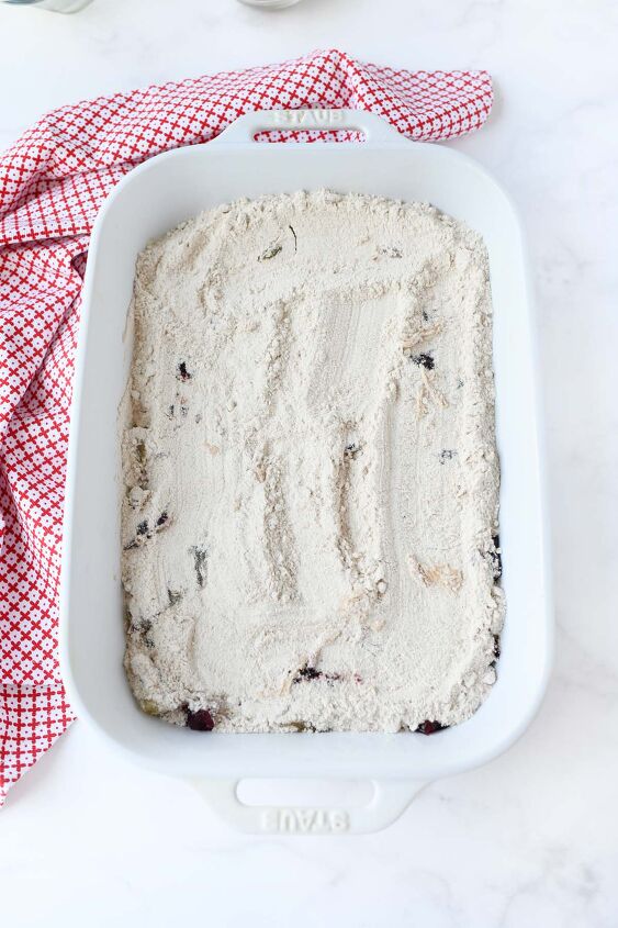 fall cranberry apple dump cake, Spice cake mix spread over fruit in a white pan