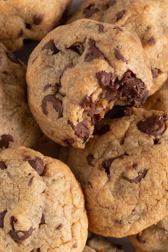 this 4 ingredient chocolate chip peanut butter cookie will be your fav, super thick and heavy chocolate chip cookies made with peanut butter loaded onto a plate one cookie has a big bite taken out of it revealing loads of chocolate chips baked inside