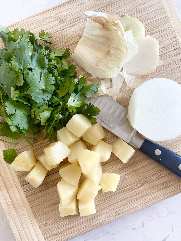 pineapple blender salsa, Cilantro pineapple and onion on a wooden cutting board