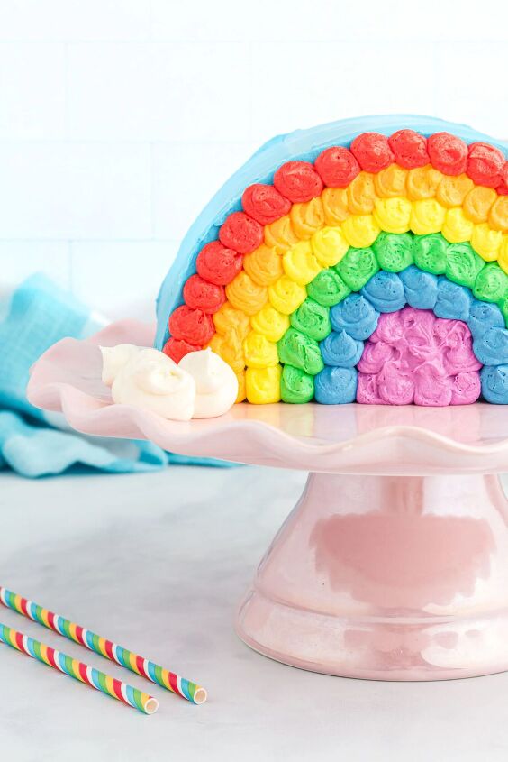 how to make a funfetti rainbow cake perfect for every celebration, pretty rainbow cake served on a shiny pink cake stand