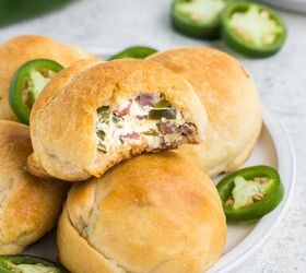 jalapeno popper rolls using crescent rolls, stacked jalapeno rolls on a plate with jalapeno pepper slices