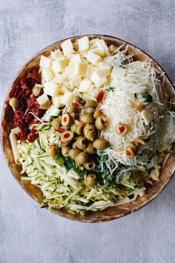 pasta salad with sun dried tomatoes green olives provolone, pasta salad ingredients in mixing bowl